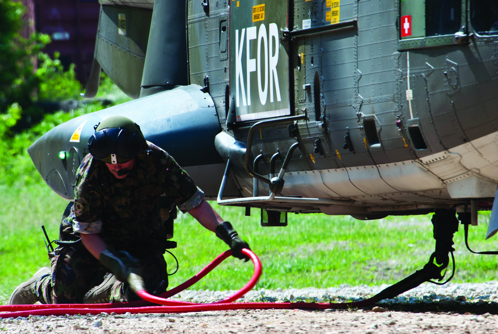 Swiss loadmaster attaches swing load cable to helicopter