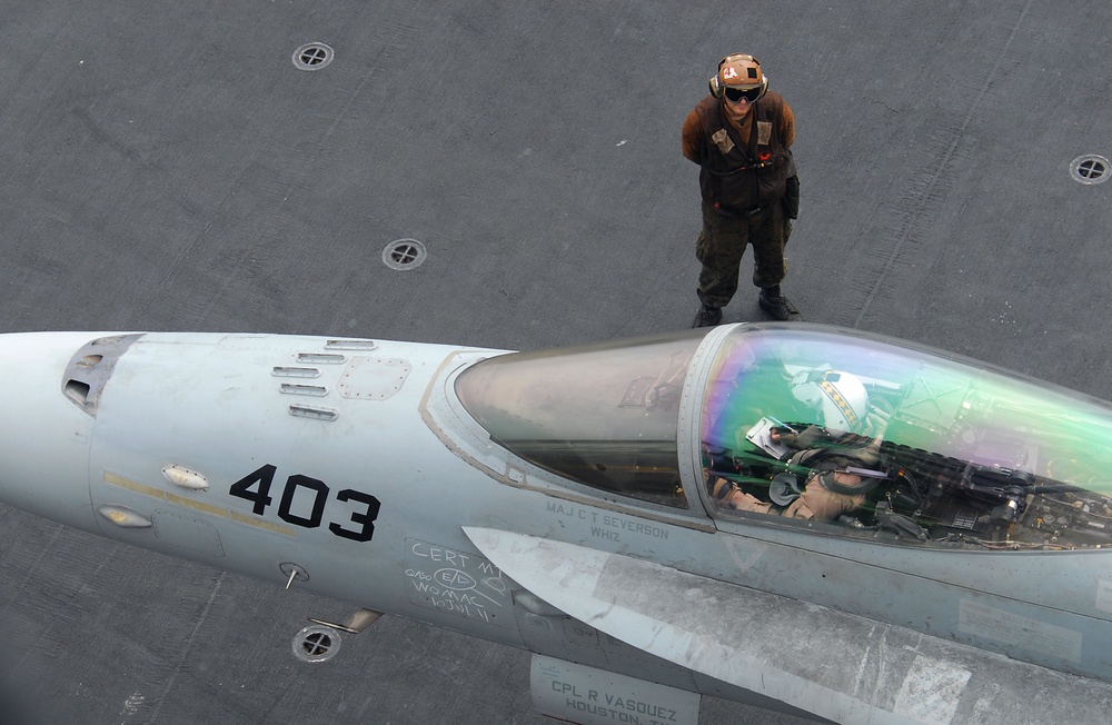 Marine plane captain performs preflight checks on F/A-18C Hornet