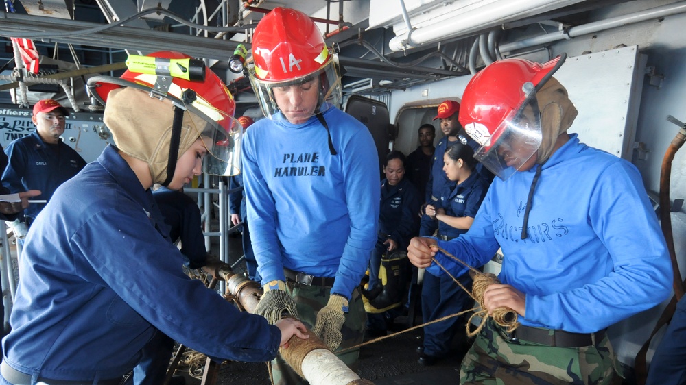 USS George Washington sailors perform a pipe patching drill