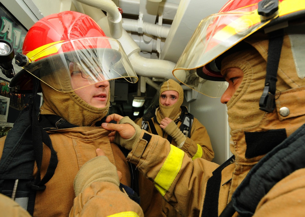 USS Bataan sailors help each dress during drill