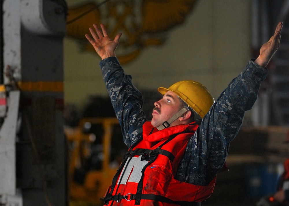 USS Abraham Lincoln rig captain directs a pallet during replenishment