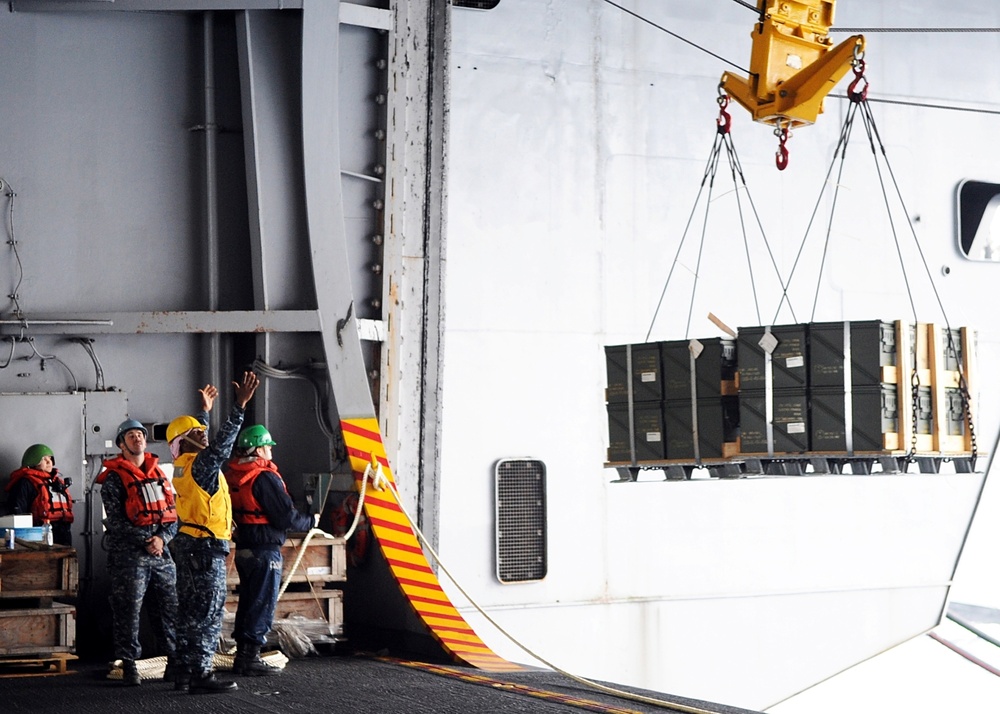 Sailors direct pallets during replenishment at sea