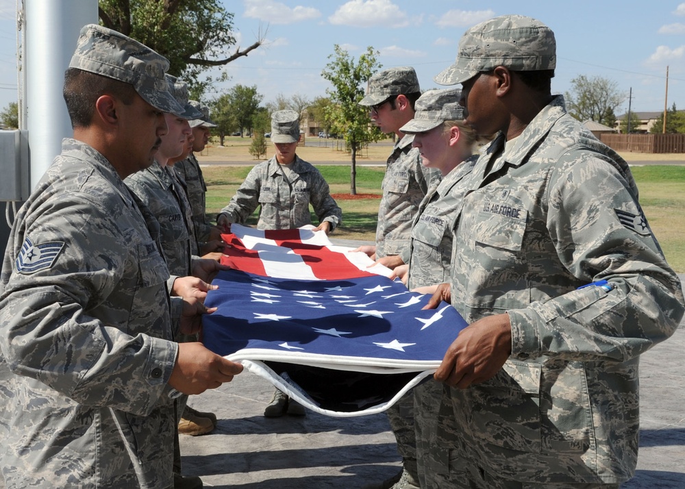 Airmen from the 97th Medical Group participate in a retreat flag folding ceremony