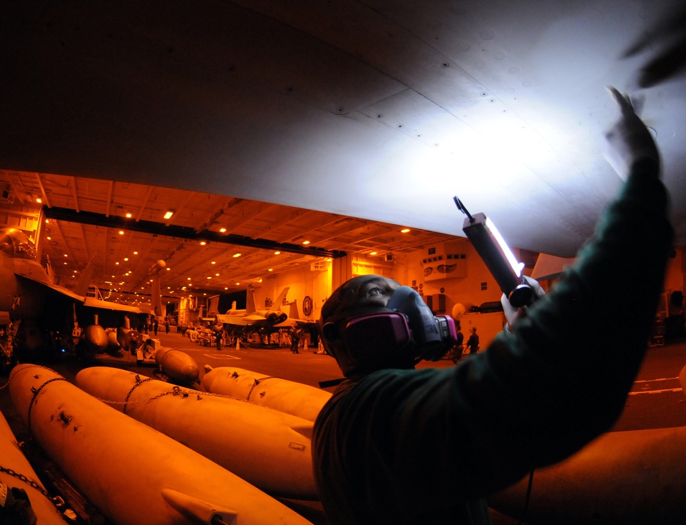 USS George H.W. Bush sailors sands  F/A-18E Super Hornet's wing