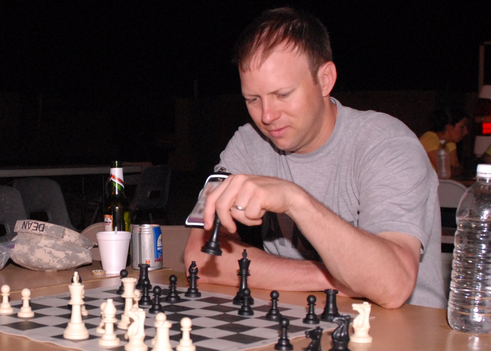 Capt. Tyler Carruth, medical provider with the Texas Medical Command, plays chess at Contingency Operating Base Basra. During his deployment to Iraq, Carruth was responsible for testing a blue-tooth enabled electrocardiogram for Black Hawk helicopters. (P