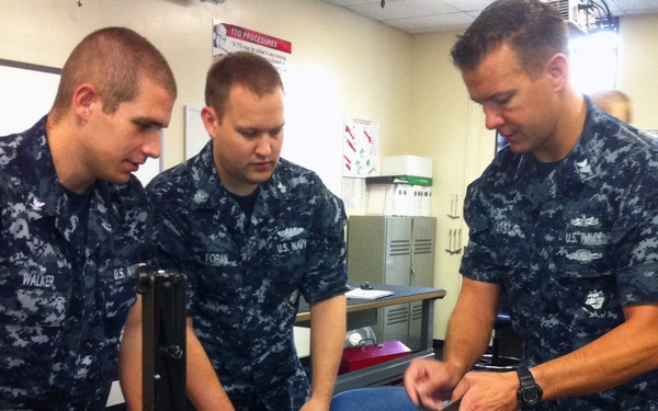 ailor demonstrates how to disassemble a machine gun