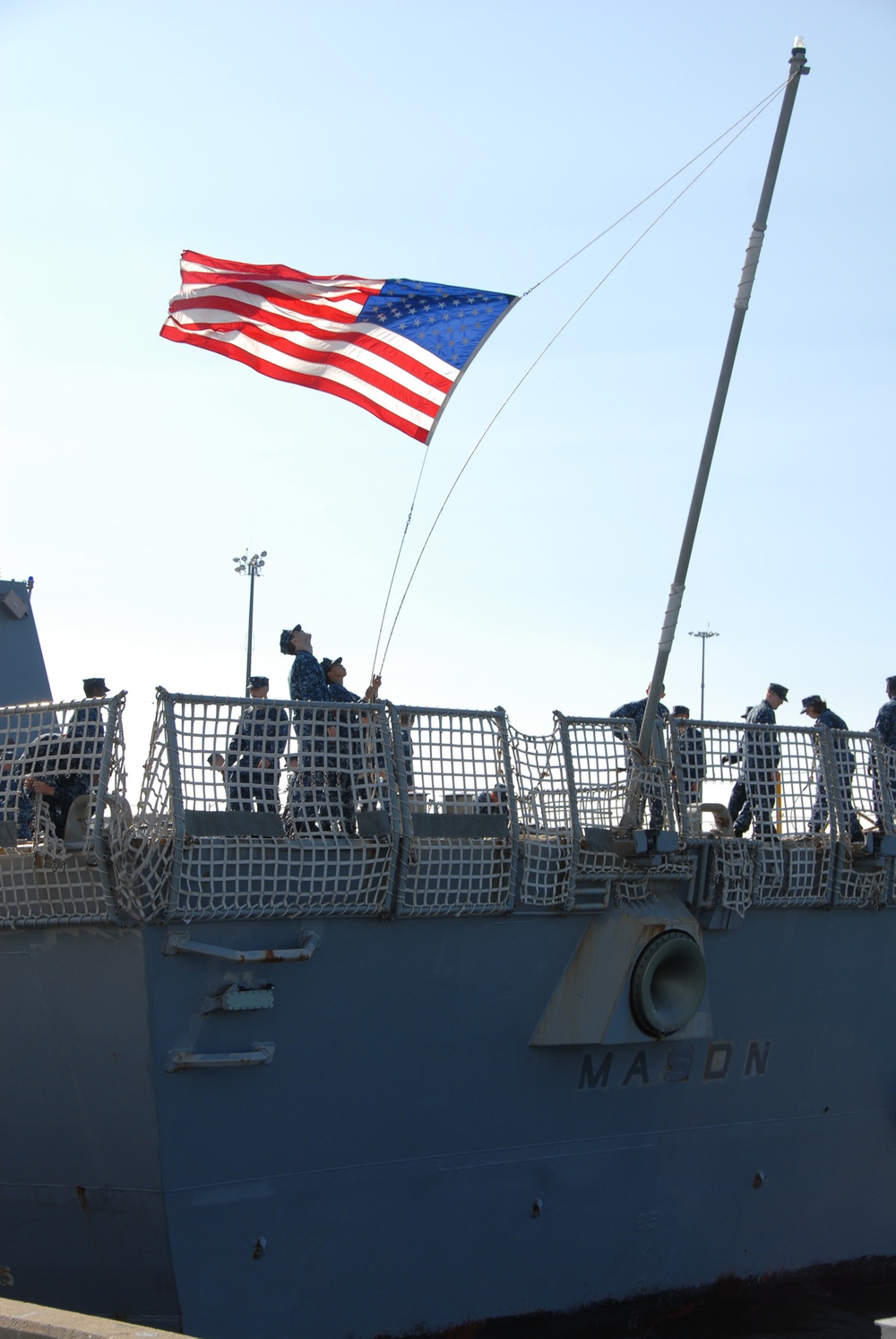 Sailors aboard the Arleigh Burke-class guided-missile destroyer USS Mason (DDG 87) lower the national ensign as they depart Naval Station Norfolk in advance of Hurricane Irene