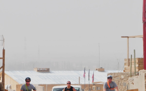 Bicyclists escort runner during Hood to Coast Satellite Run in Afghanistan
