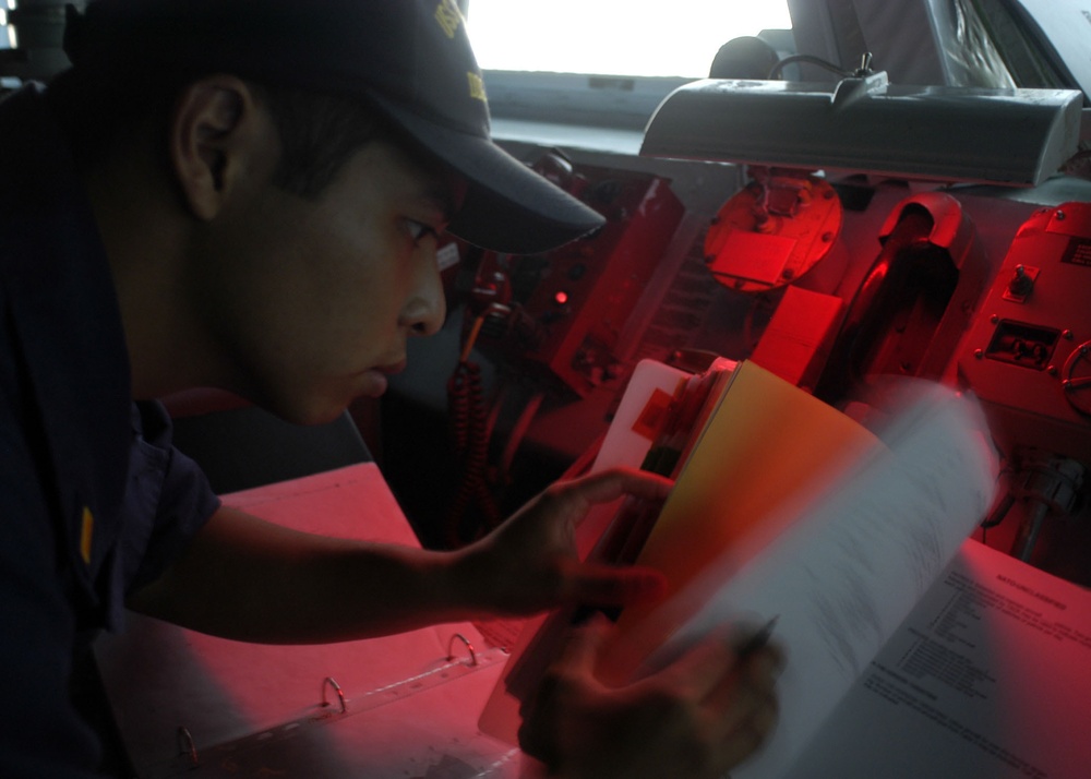 USS Curtis Wilbur sailor consults a reference