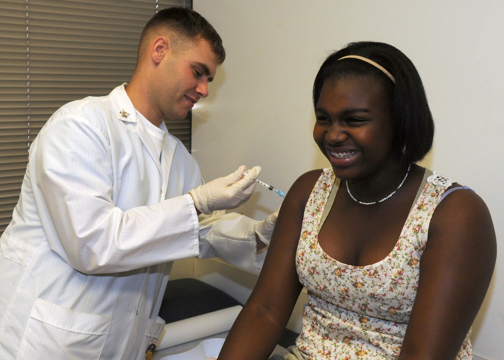 Sailor gives student immunization shot