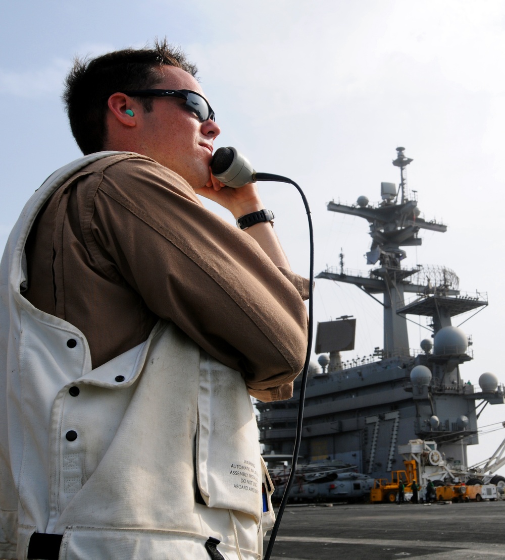 USS George H.W. Bush sailor guides landing