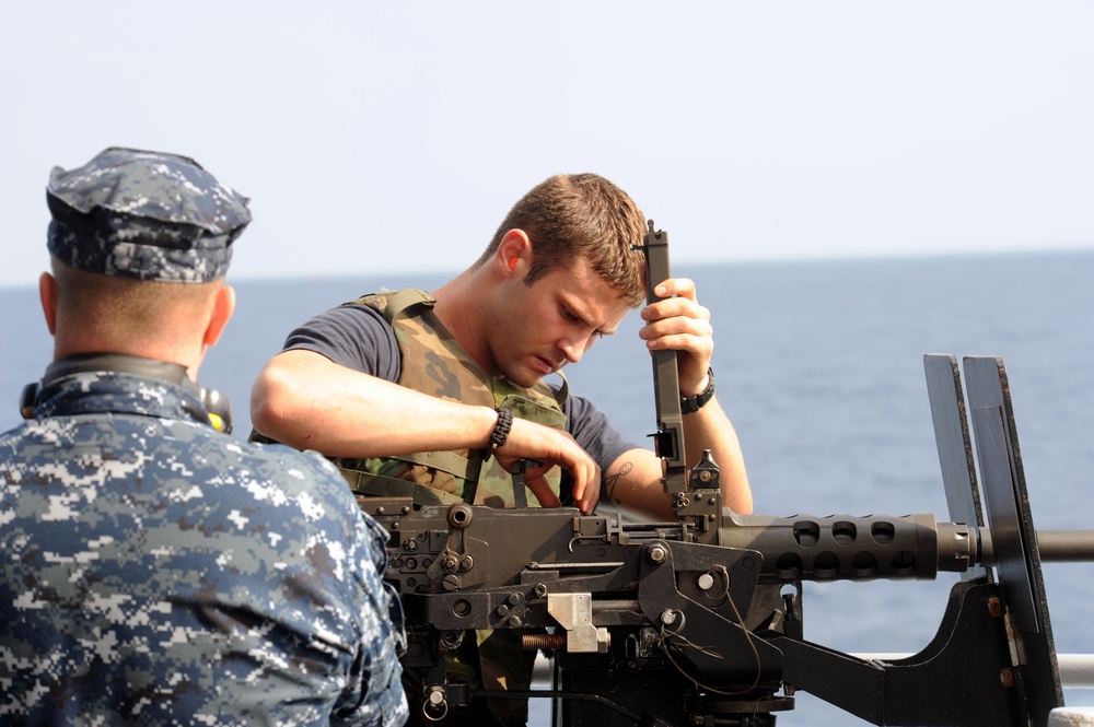 USS Dwight D. Eisenhower sailor checks machine gun