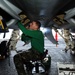 Sailor cleans out debris under F/A-18C Hornet