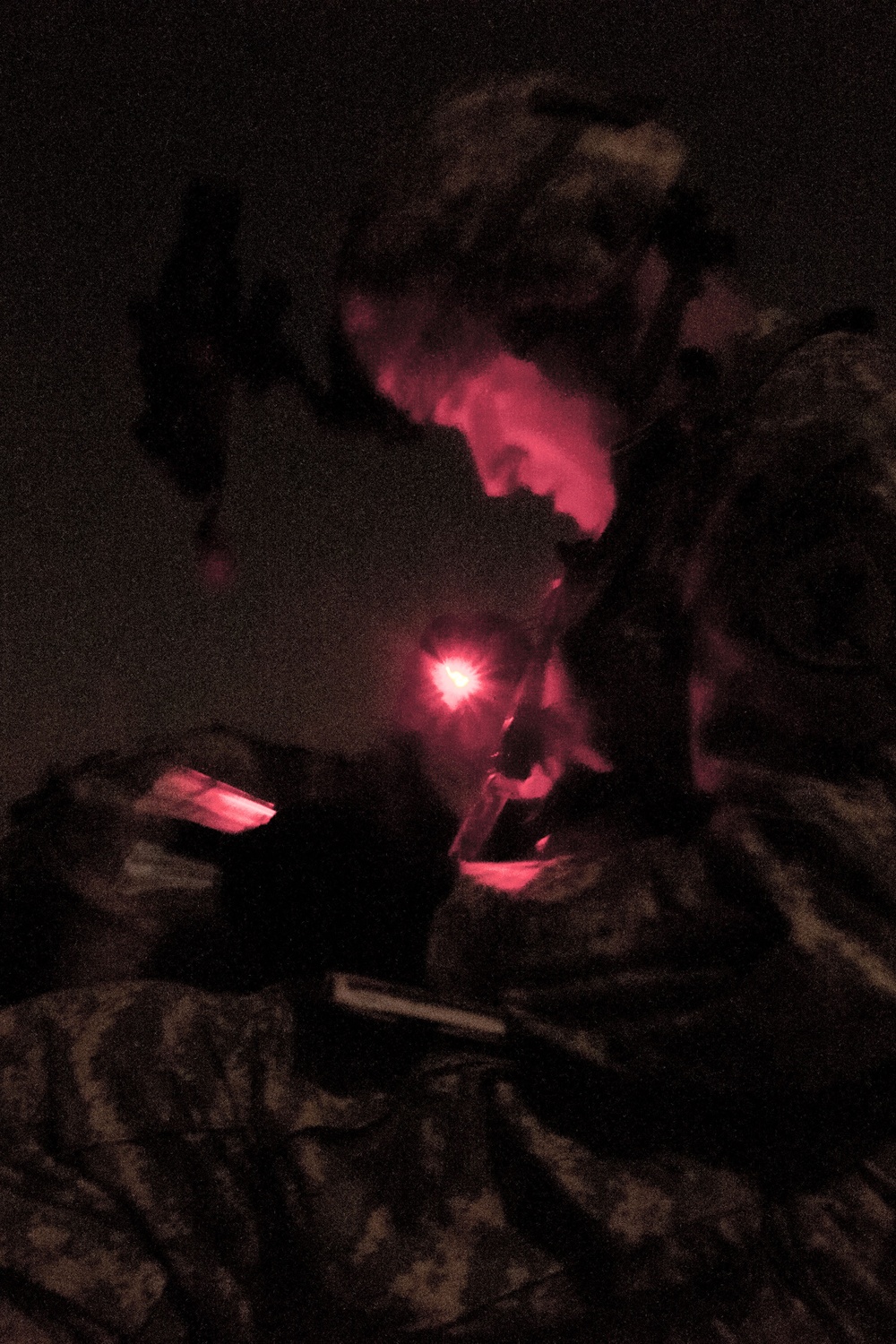 Paratrooper checks map to determine objective point