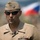 New SACEUR makes first visit to Kosovo A high-ranking U.S. Navy officer in service dress khaki uniform is photographed outdoors, wearing sunglasses and a garrison cap. He displays four-star rank insignia on both collar points and cap, along with a surface warfare badge and several service ribbons. A blurred flag with red, white, and blue horizontal stripes — consistent with the Czech Republic flag — is visible in the background.