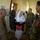 New SACEUR makes first visit to Kosovo A group of military personnel from multiple nations are engaged in conversation with a civilian woman wearing a white headscarf inside what appears to be a building with informational plaques on the walls. A Turkish Armed Forces soldier is prominently visible on the right, identifiable by the 'Türkiye' patch with the crescent and star emblem. The scene suggests a multinational military visit or liaison meeting with a local civilian.