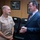 New SACEUR makes first visit to Kosovo Two men are engaged in conversation in what appears to be an official office or conference room setting. One man is wearing a tan/khaki U.S. Navy uniform with rank insignia, medals, and a warfare qualification badge, while the other is dressed in a dark business suit with a striped tie. The setting suggests a formal diplomatic or military meeting.