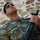 New SACEUR makes first visit to Kosovo A male soldier in camouflage uniform is leaning against a stone wall while holding an automatic rifle. He is wearing a green beret and a name tape reading 'BASER' on his chest pocket. The image appears to depict a Turkish military serviceman based on the distinctive camouflage pattern and uniform details.