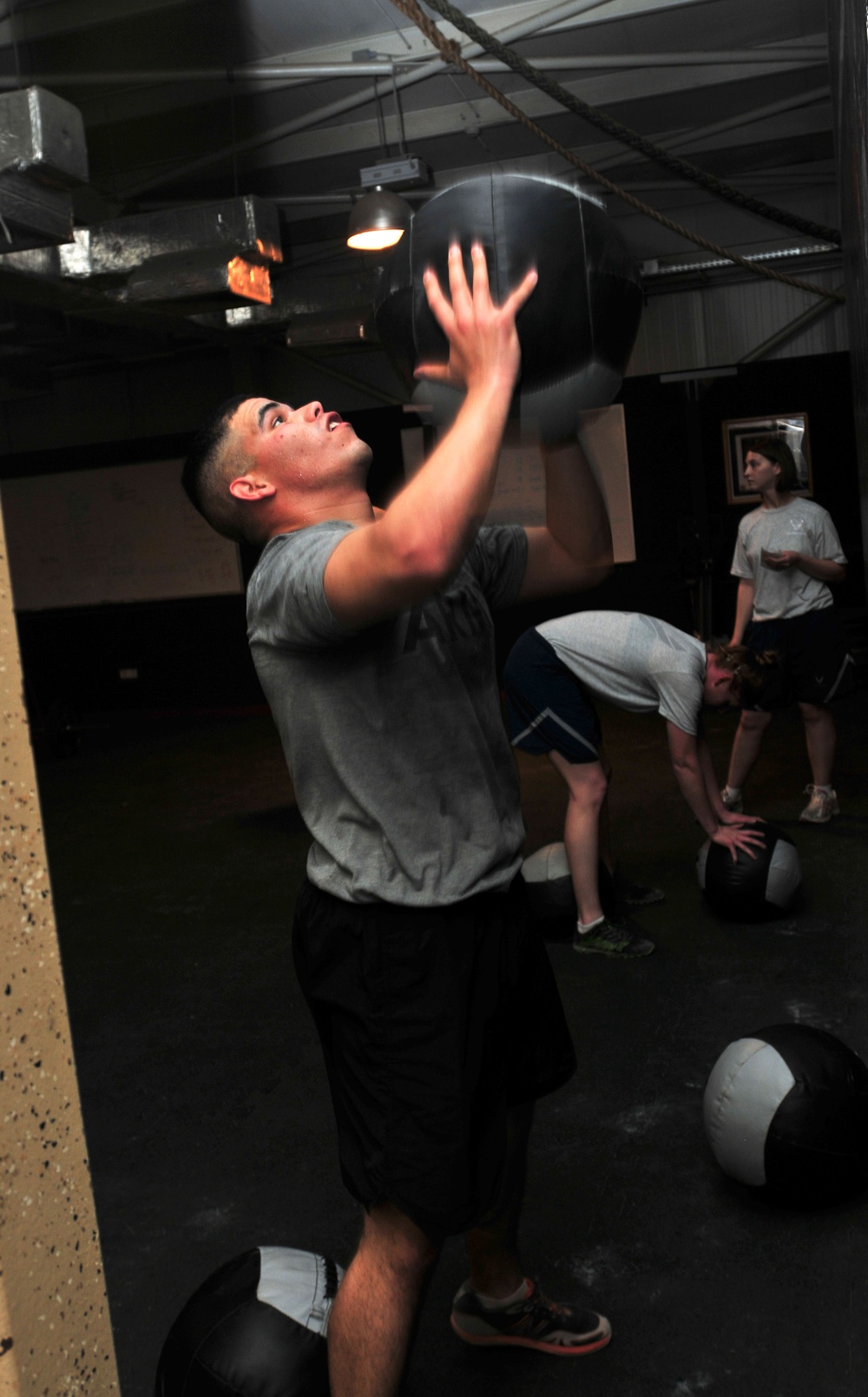 Soldier tosses a medicine ball while working out