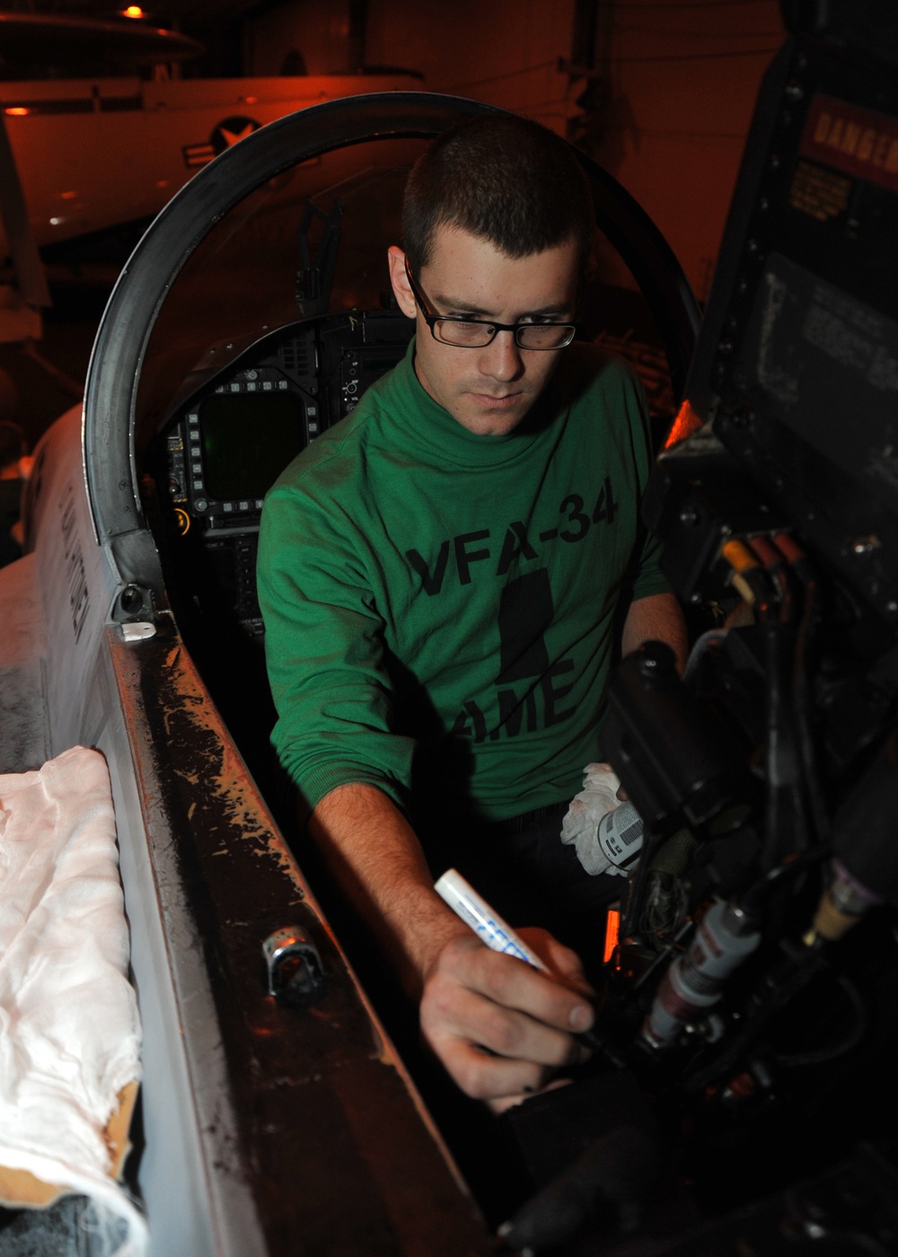 USS Abraham Lincoln sailor conducts maintenance on F/A-18C Hornet