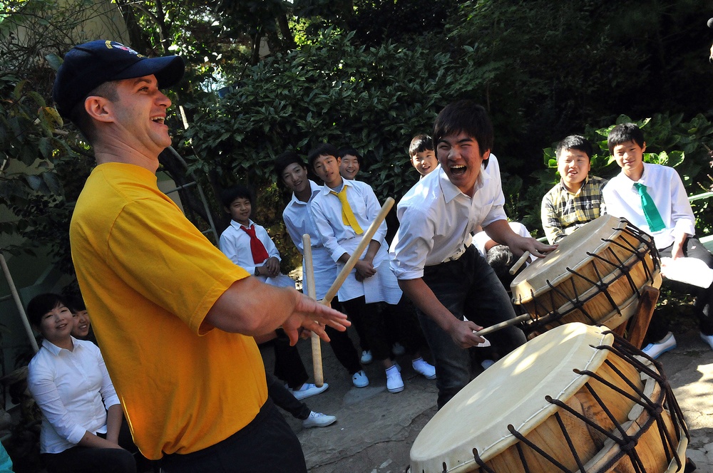 USS George Washingto sailor plays drums with children