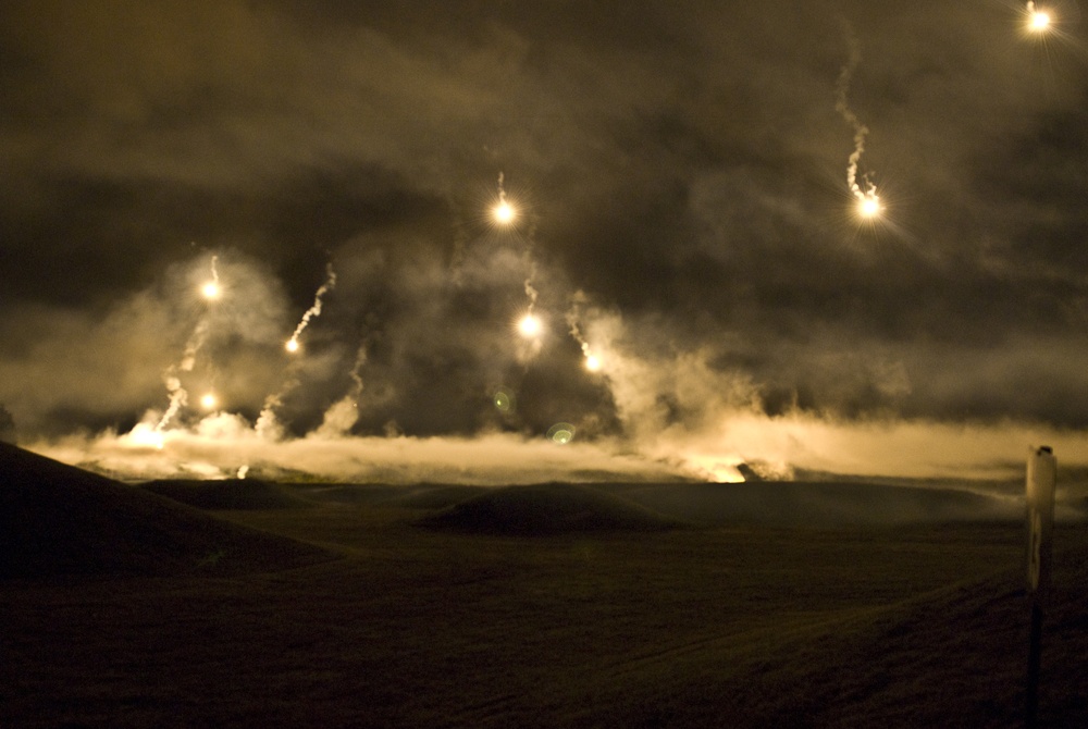 Flares parachute and illuminate the Department of the Army Best Warrior Night Fire