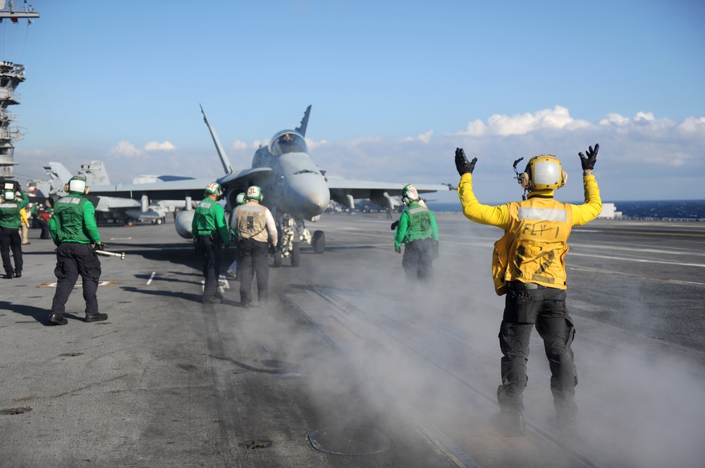 Sailor signals pilot aboard USS Dwight D. Eisenhower