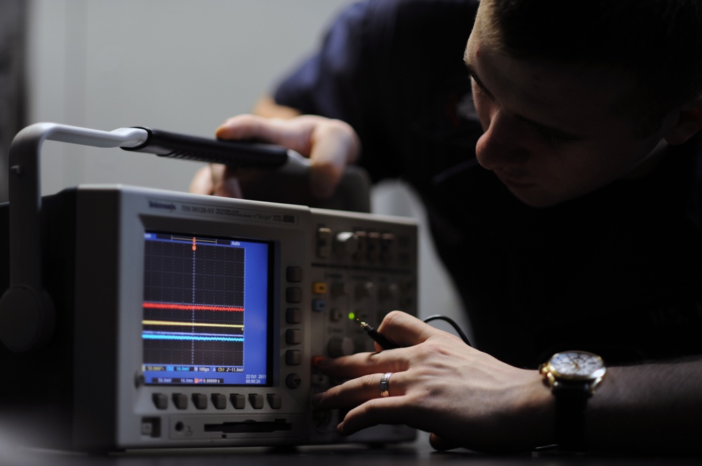 USS George H.W. Bush sailors work on electronics