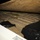 Operation Pipeline Express drug arrests The image shows a concealed compartment in what appears to be a vehicle, with a plywood panel lifted to reveal numerous tightly wrapped rectangular packages underneath. The packages are consistent in appearance with contraband bundles typically documented in law enforcement seizure photography. This appears to be an evidence or documentation photograph taken at night.