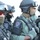 Operation Pipeline Express Drug Arrests The image shows a group of heavily equipped law enforcement officers from HSI (Homeland Security Investigations) Los Angeles Special Response Team. Officers are wearing tactical gear including ballistic helmets, protective goggles, face coverings, body armor, and are carrying firearms. The image appears to be taken during a tactical operation or training exercise.