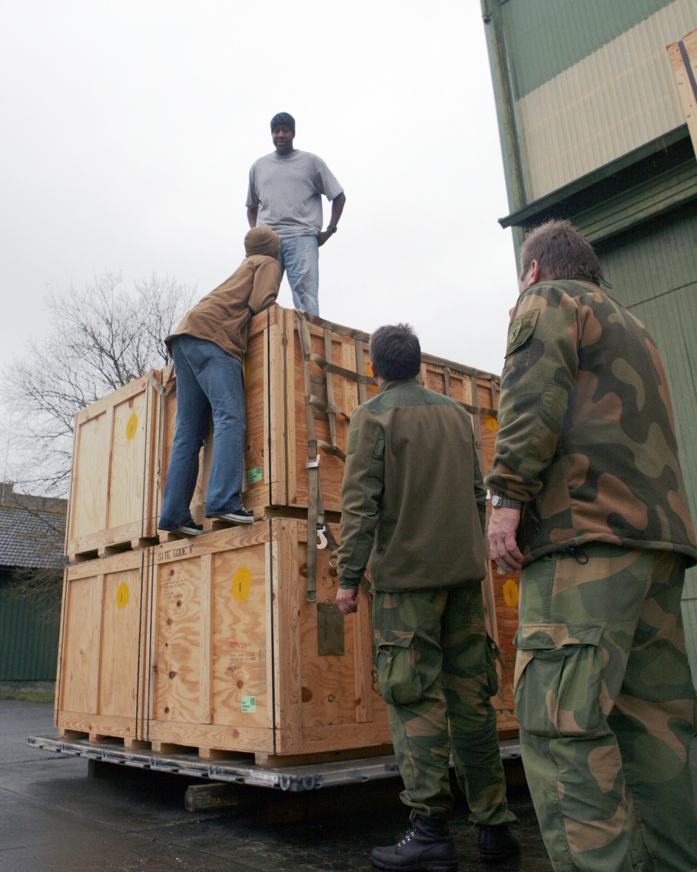 Marines and Norwegian military members assemble Air Force pallets of supplies for earthquake victims in Eastern Turkey