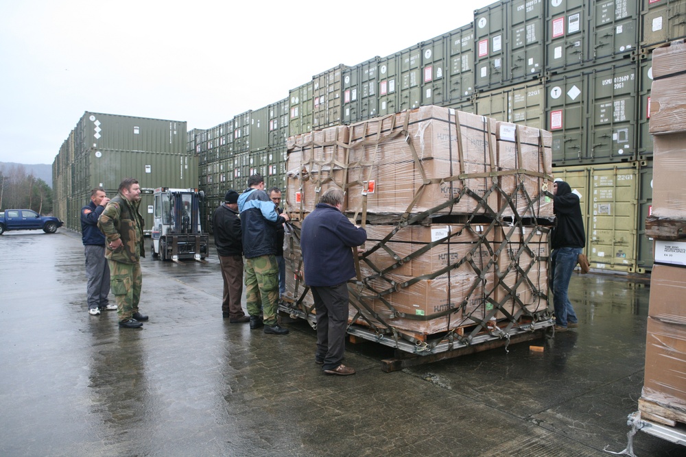 Marines and Norwegien military members asseble Air Force pallets of supplies for earthquake victims in Eastern Turkey