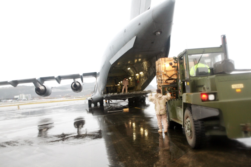 Marines and airmen load a C-17 with pallets of supplies for earthquake victims in eastern Turkey