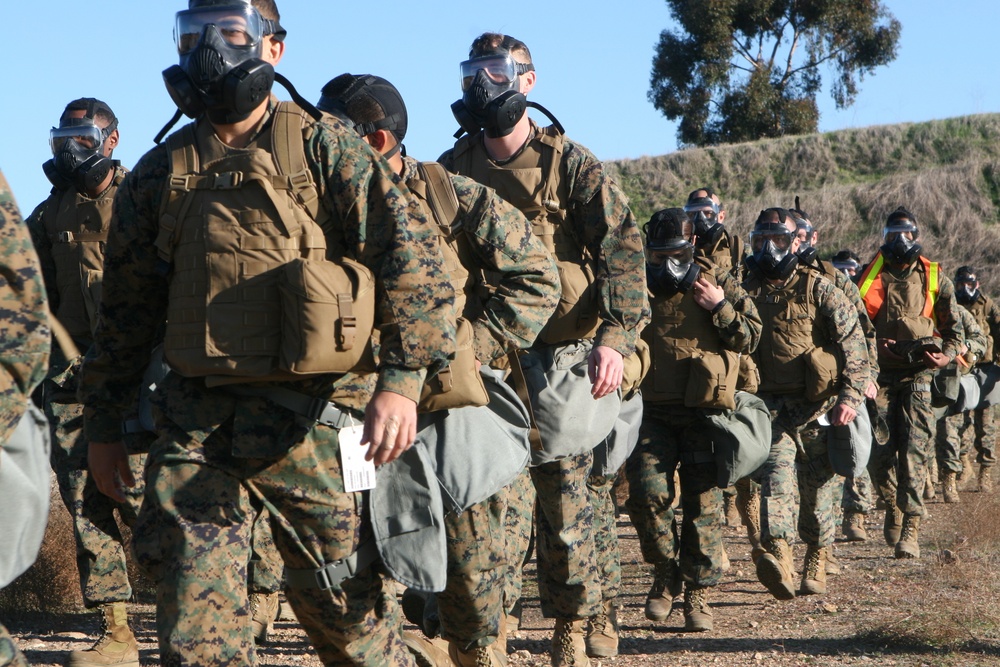 Headquarters and Headquarters Squadron hikes, trains with gas masks