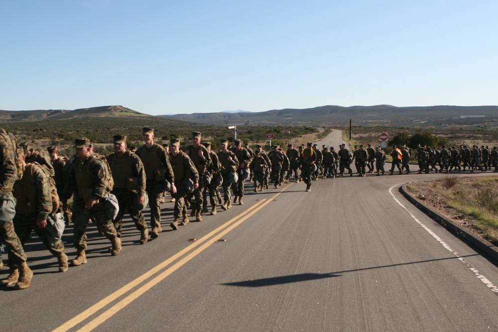 Headquarters and Headquarters Squadron hikes, trains with gas masks