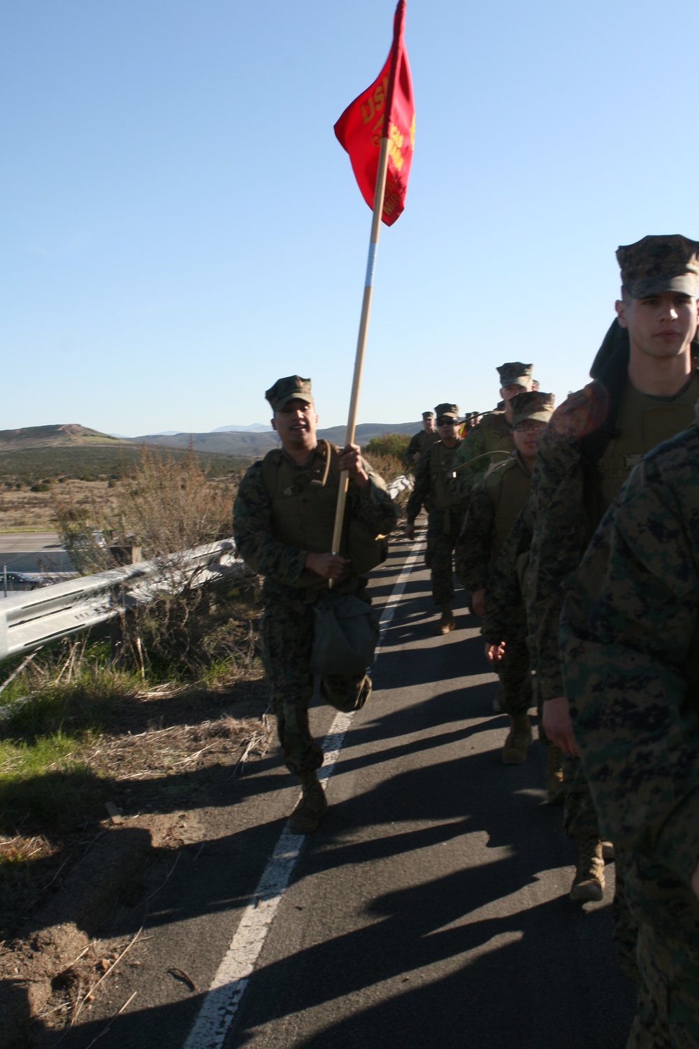 Headquarters and Headquarters Squadron hikes, trains with gas masks