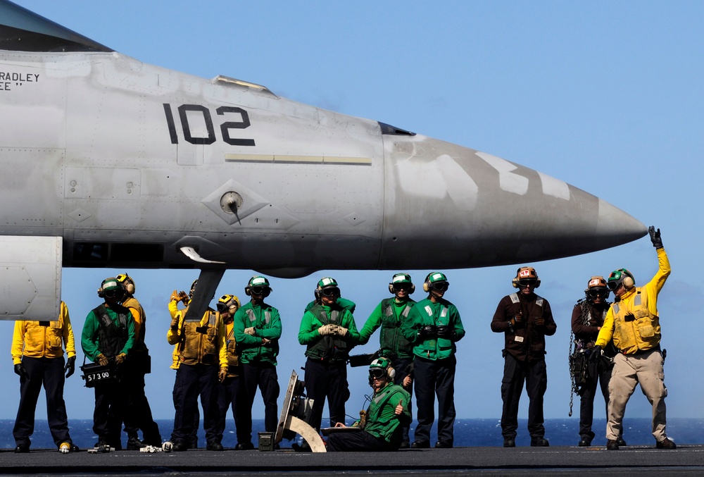 Sailor signals before launch aboard USS Carl Vinson