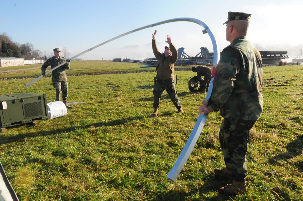 Combat Service Support Detachment Seabees take apart a metal frame