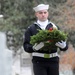 Sailor carries wreath in cemetery