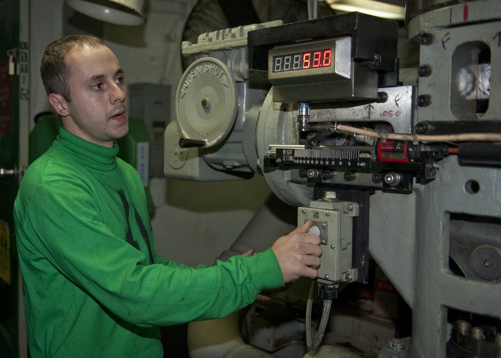 USS Enterprise sailor explais gear during tour