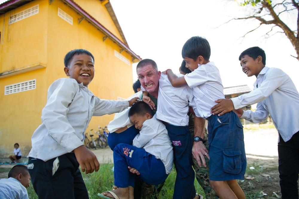 11 MEU Marine plays with children at school