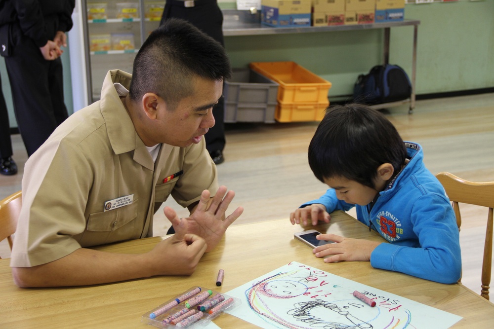USS Cowpens sailor plays with a Japanese orphan