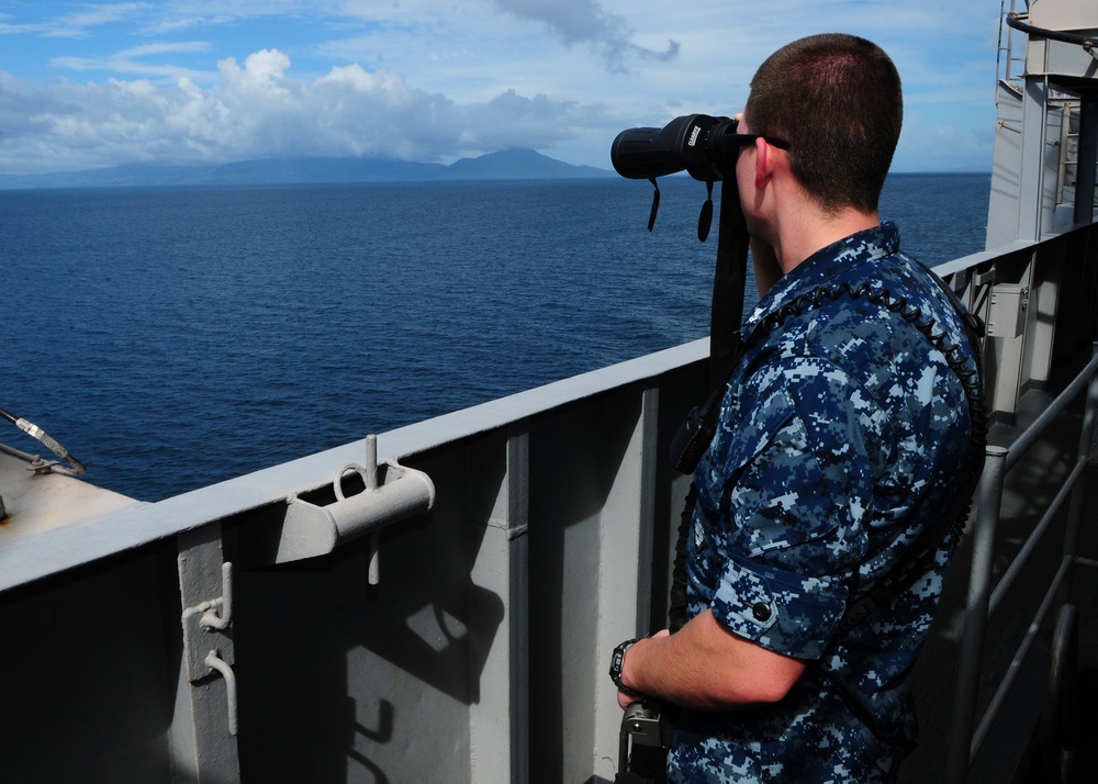 USS Abraham Lincoln sailor views island coast