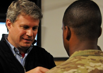 Michigan Representative Huizenga pins on a soldier's award