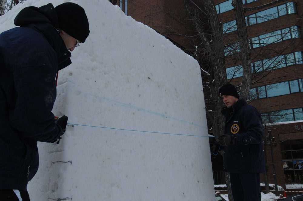 Navy Misawa snow sculpture team begins work on "The Lone Sailor" sculpture