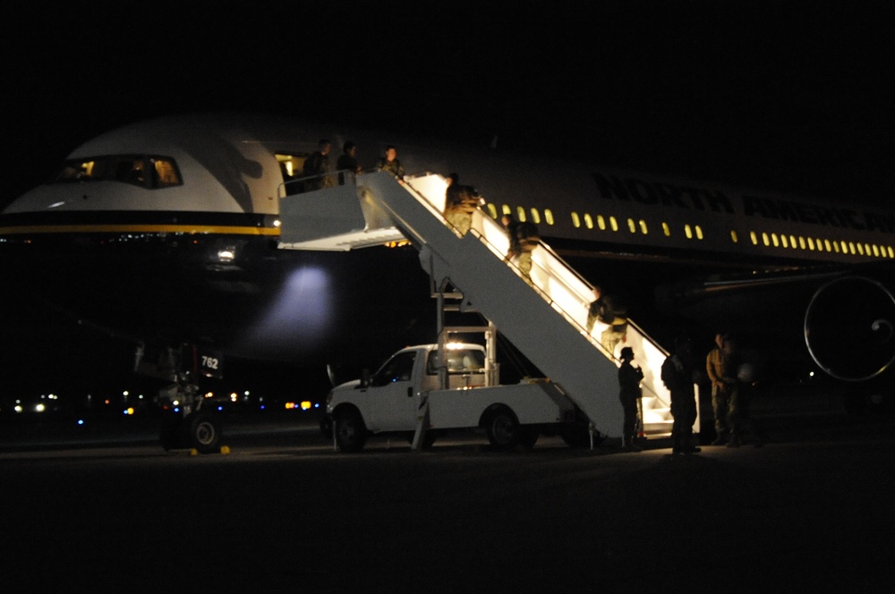 Seabees board plane late at night for deployment