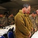 NATO service members bow their heads during the invocation at National Prayer Breakfast