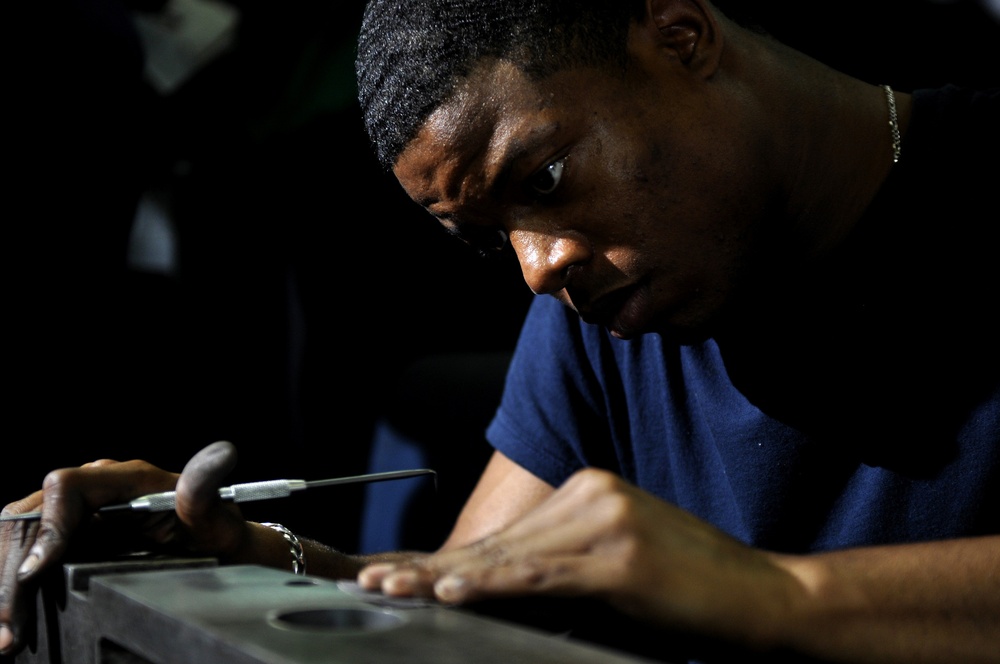 USS Carl Vinson sailor cleans catapult spreader