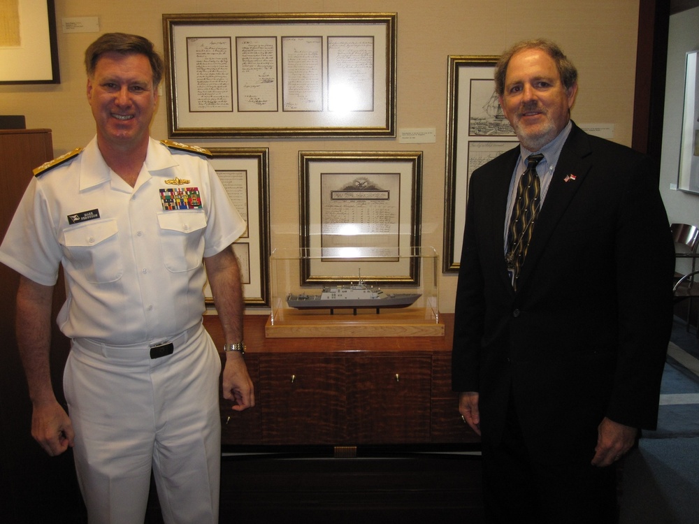 Naval leaders pose in front of USS Freedom model