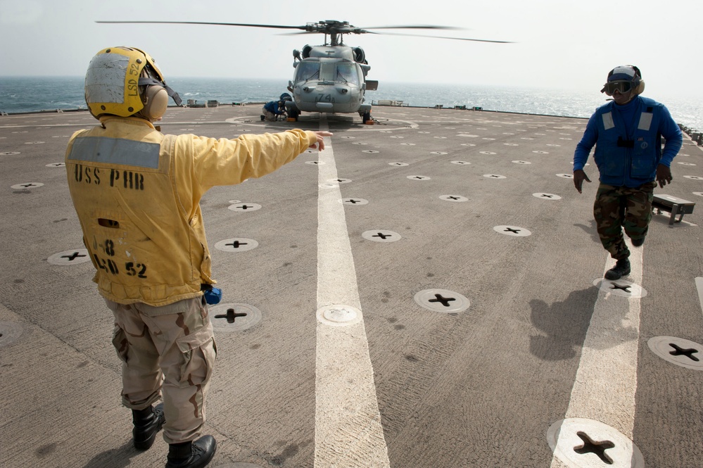 Sailors signal MH-60S Sea Hawk launch